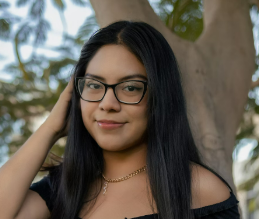 Smiling woman with glasses by tree